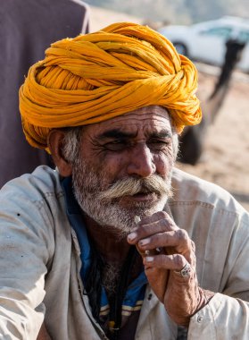 Puşkar, Rajasthan, Hindistan - Kasım 2019: Rajasthan 'lı Hintli erkekler fuar sırasında açık arazide sigara içiyorlar