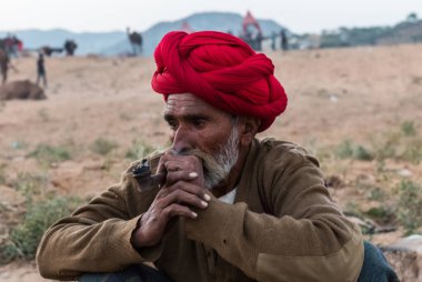 Puşkar, Rajasthan, Hindistan Ekim 2017: Kafasında Puro ve Kızıl Türbanlı Rajasthani Yaşlısı 