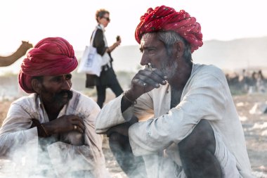 Puşkar, Rajasthan / Hindistan - Kasım 2019: Rajasthan halkı fuar alanında grup halinde chilam içiyor 