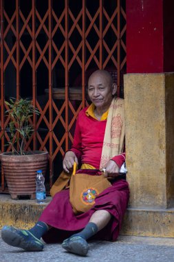 Yeni Delhi, Hindistan - Aralık 2021: Tibet manastırı bölgesinde kırmızı giysili Hint Tibet keşişi lama.