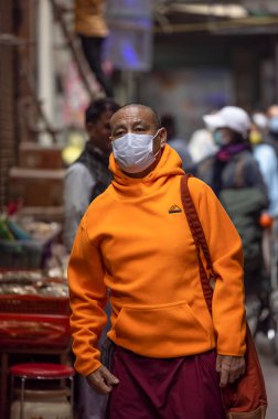 Yeni Delhi, Hindistan - Aralık 2021: Tibet manastırı bölgesinde kırmızı giysili Hint Tibet keşişi lama.