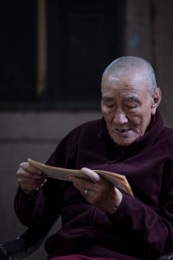 Yeni Delhi, Hindistan - Aralık 2021: Tibet manastırı bölgesinde kırmızı giysili Hint Tibet keşişi lama.