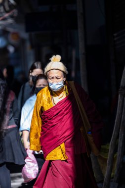 Yeni Delhi, Hindistan - Aralık 2021: Tibet manastırı bölgesinde kırmızı giysili Hint Tibet keşişi lama.