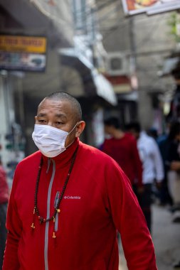 Yeni Delhi, Hindistan - Aralık 2021: Tibet manastırı bölgesinde kırmızı giysili Hint Tibet keşişi lama.