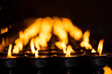 Tibet manastırında koyu siyah arka planda Diya yağ lambası yanıyor.