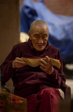 Yeni Delhi, Hindistan - Aralık 2021: Tibet manastırı bölgesinde kırmızı giysili Hint Tibet keşişi lama.