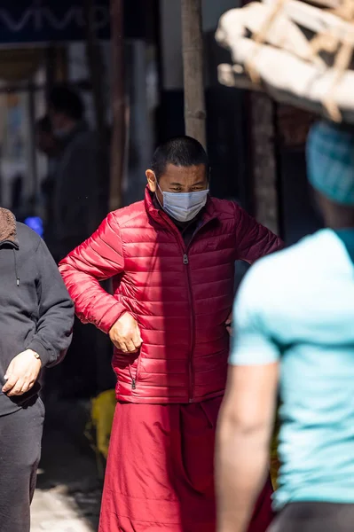 Yeni Delhi, Hindistan - Aralık 2021: Tibet manastırı bölgesinde kırmızı giysili Hint Tibet keşişi lama.