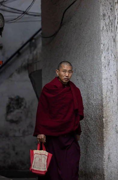 Yeni Delhi, Hindistan - Aralık 2021: Tibet manastırı bölgesinde kırmızı giysili Hint Tibet keşişi lama.