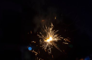 Diwali Festivali 'ni kutlamak için elinde koyu siyah arka planla Sparkler ya da Fuljhadi.