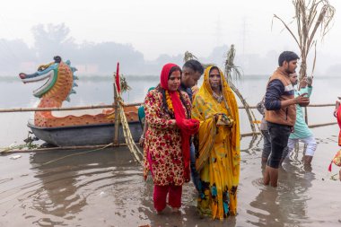 Ghaziabad, Uttar Pradesh, India - November 2021: Chhath Puja, Indian hindu devotees performing rituals of chhath puja in the night near river bank.