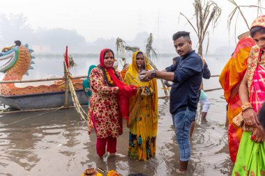 Ghaziabad, Uttar Pradesh, India - November 2021: Chhath Puja, Indian hindu devotees performing rituals of chhath puja in the night near river bank.