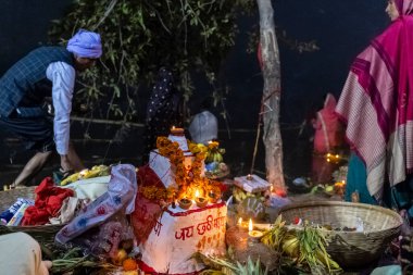 Ghaziabad, Uttar Pradesh, India - November 2021: Chhath Puja, Indian hindu devotees performing rituals of chhath puja in the night near river bank.