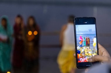 Ghaziabad, Uttar Pradesh, India - November 2021: Chhath Puja, Indian hindu devotees performing rituals of chhath puja in the night near river bank.