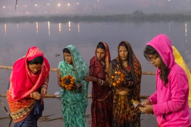 Ghaziabad, Uttar Pradesh, India - November 2021: Chhath Puja, Indian hindu devotees performing rituals of chhath puja in the night near river bank.