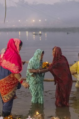 Ghaziabad, Uttar Pradesh, India - November 2021: Chhath Puja, Indian hindu devotees performing rituals of chhath puja in the night near river bank.
