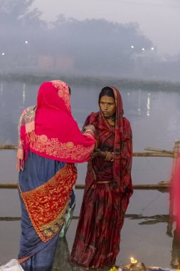Ghaziabad, Uttar Pradesh, India - November 2021: Chhath Puja, Indian hindu devotees performing rituals of chhath puja in the night near river bank.