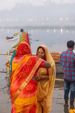 Ghaziabad, Uttar Pradesh, India - November 2021: Chhath Puja, Indian hindu devotees performing rituals of chhath puja in the night near river bank.