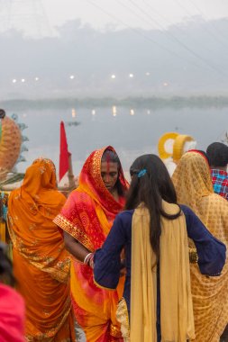 Ghaziabad, Uttar Pradesh, India - November 2021: Chhath Puja, Indian hindu devotees performing rituals of chhath puja in the night near river bank.
