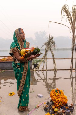 Ghaziabad, Uttar Pradesh, India - November 2021: Chhath Puja, Indian hindu devotees performing rituals of chhath puja in the night near river bank. clipart