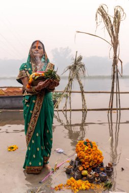 Ghaziabad, Uttar Pradesh, India - November 2021: Chhath Puja, Indian hindu devotees performing rituals of chhath puja in the night near river bank.