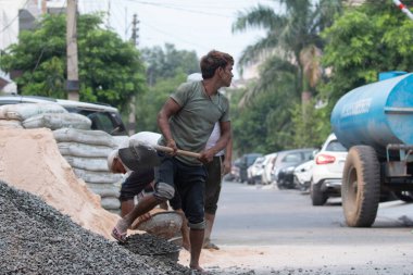 GHAZIABAD, UTTAR PRADESH, Hindistan - Ekim 2021: İnşaat alanında çalışan tanımlanamayan Hintli erkek işçiler.  