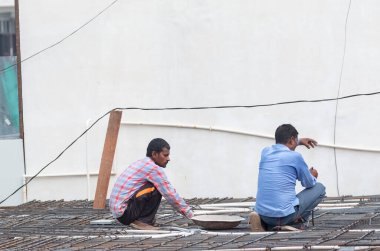 GHAZIABAD, UTTAR PRADESH, Hindistan - Ekim 2021: İnşaat alanında çalışan tanımlanamayan Hintli erkek işçiler.  