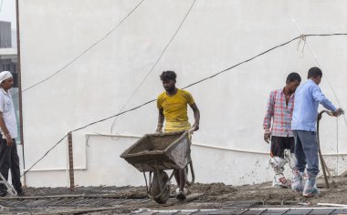 GHAZIABAD, UTTAR PRADESH, Hindistan - Ekim 2021: İnşaat alanında çalışan tanımlanamayan Hintli erkek işçiler.  