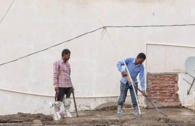 GHAZIABAD, UTTAR PRADESH, Hindistan - Ekim 2021: İnşaat alanında çalışan tanımlanamayan Hintli erkek işçiler.  