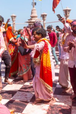 Barsana, Uttar Pradesh, Hindistan - Mart 2022: Barsana 'daki Radha Rani tapınağında renkli kuru renklerle Holi Festivali' nin tadını çıkaran ve dans eden tanımlanamayan insanlar.