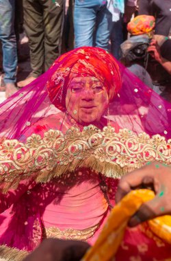 Barsana, Uttar Pradesh, Hindistan - Mart 2022: Barsana 'daki Radha Rani tapınağında renkli kuru renklerle Holi Festivali' nin tadını çıkaran ve dans eden tanımlanamayan insanlar.