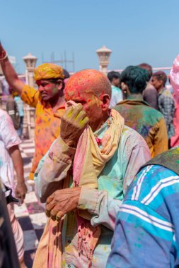 Barsana, Uttar Pradesh, Hindistan - Mart 2022: Barsana 'daki Radha Rani tapınağında renkli kuru renklerle Holi Festivali' nin tadını çıkaran ve dans eden tanımlanamayan insanlar.