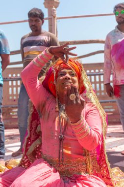 Barsana, Uttar Pradesh, Hindistan - Mart 2022: Barsana 'daki Radha Rani tapınağında renkli kuru renklerle Holi Festivali' nin tadını çıkaran ve dans eden tanımlanamayan insanlar.