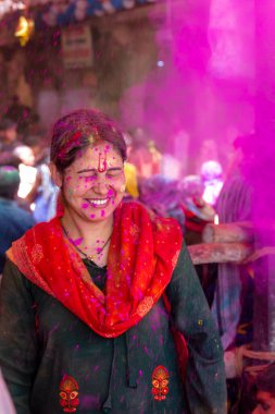 Barsana, Uttar Pradesh, Hindistan - Mart 2022: Barsana 'daki Radha Rani tapınağında renkli kuru renklerle Holi Festivali' nin tadını çıkaran ve dans eden tanımlanamayan insanlar.