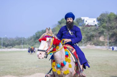 Anandpur Sahib, Punjab, India - March 2022: Portrait of sikh male (Nihang Sardar) during the celebration of Hola Mohalla at Anandpur Sahib on holi festival.