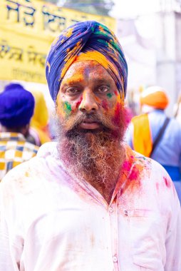 Anandpur Sahib, Punjab, India - March 2022: Celebration of Hola Mohalla at Anandpur Sahib during holi festival. Selective focus on colorful face.