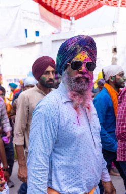 Anandpur Sahib, Punjab, Hindistan - Mart 2022: Holi festivali sırasında Hola Mohalla 'nın Anandpur Sahib' de kutlanması. Renkli yüze seçici odaklanma.