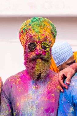 Anandpur Sahib, Punjab, Hindistan - Mart 2022: Holi festivali sırasında Hola Mohalla 'nın Anandpur Sahib' de kutlanması. Renkli yüze seçici odaklanma.