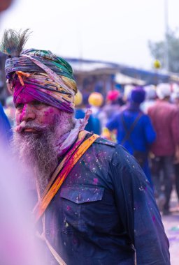 Anandpur Sahib, Punjab, Hindistan - Mart 2022: Holi festivali sırasında Hola Mohalla 'nın Anandpur Sahib' de kutlanması. Renkli yüze seçici odaklanma.