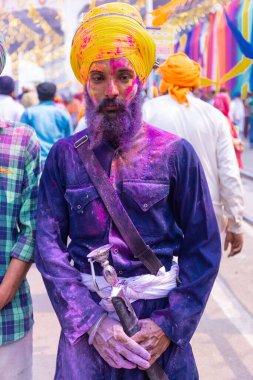 Anandpur Sahib, Punjab, Hindistan - Mart 2022: Holi festivali sırasında Hola Mohalla 'nın Anandpur Sahib' de kutlanması. Renkli yüze seçici odaklanma.