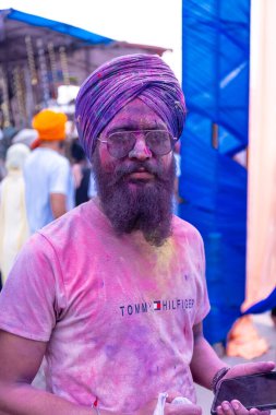 Anandpur Sahib, Punjab, Hindistan - Mart 2022: Holi festivali sırasında Hola Mohalla 'nın Anandpur Sahib' de kutlanması. Renkli yüze seçici odaklanma.