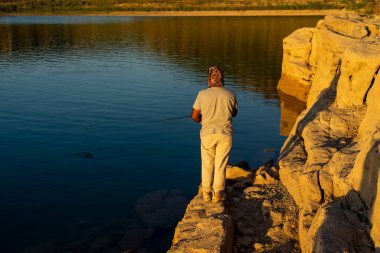 Persona pescando on lago al atardecer