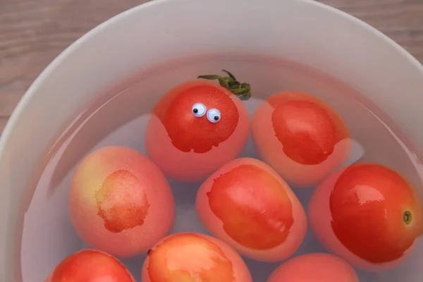 Czerwone Pomidory Misce Wody Jeden Zabawnymi Oczami Lalki Świeże Owoce — Zdjęcie stockowe