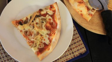 Lezzetli bir yaz aperatifi: Bir parça ev yapımı mantarlı pizza ve beyaz tabakta yumuşak peynir. Üst görünüm.