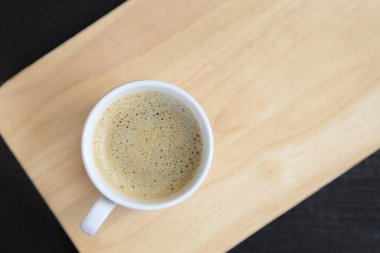 Kremalı kahve fincanı ahşap zemin, fotokopi alanı olan üst manzara..