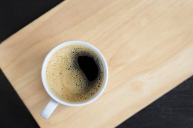 Kremalı kahve fincanı ahşap zemin, fotokopi alanı olan üst manzara..