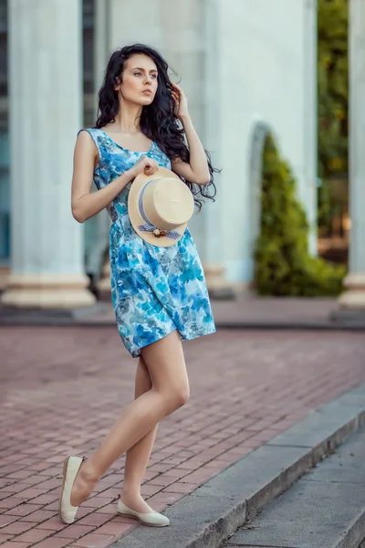 Affascinante ragazza in piedi e tenendo il cappello tra le mani . — Foto Stock