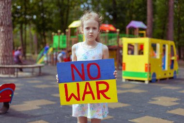 Ukrainian girl child asks to stop the war. In her hands board no war.