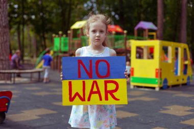 Ukrainian girl child asks to stop the war. In her hands board no war.