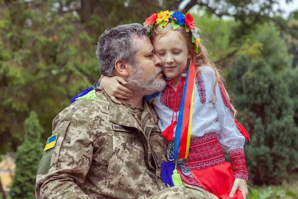 Little Ukrainian girl meets dad from the war. Ukraine, conflict, war.