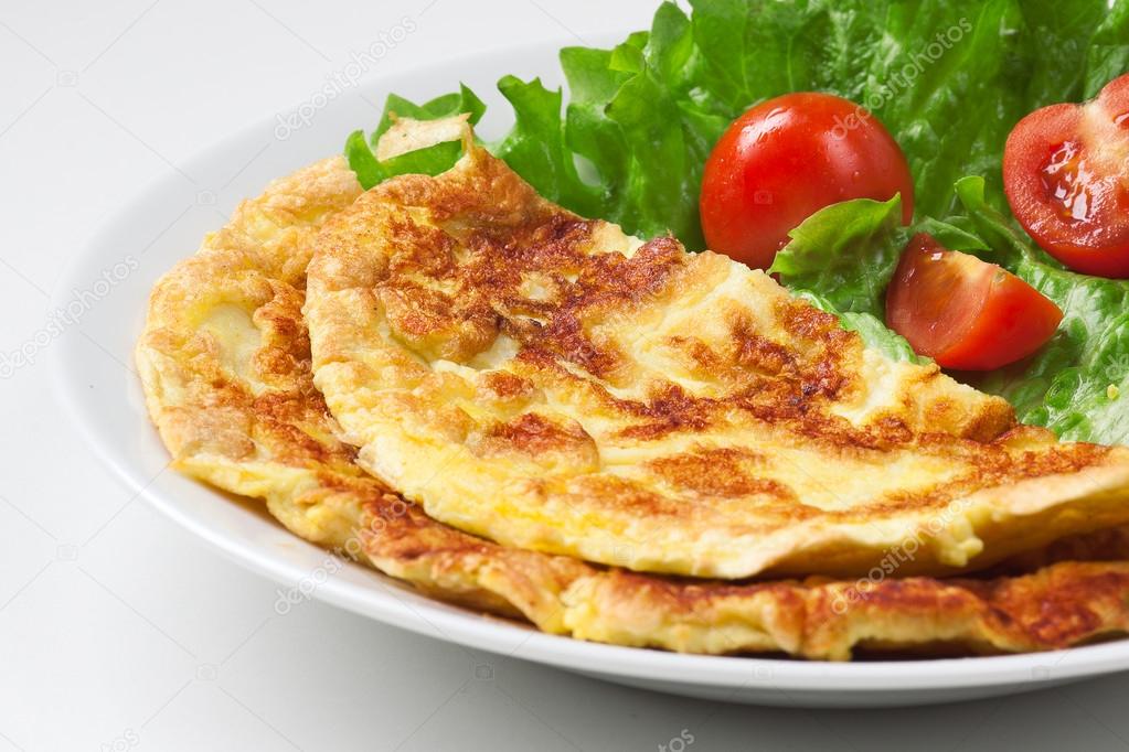 Omelette with cherry tomato and green salad on white plate
